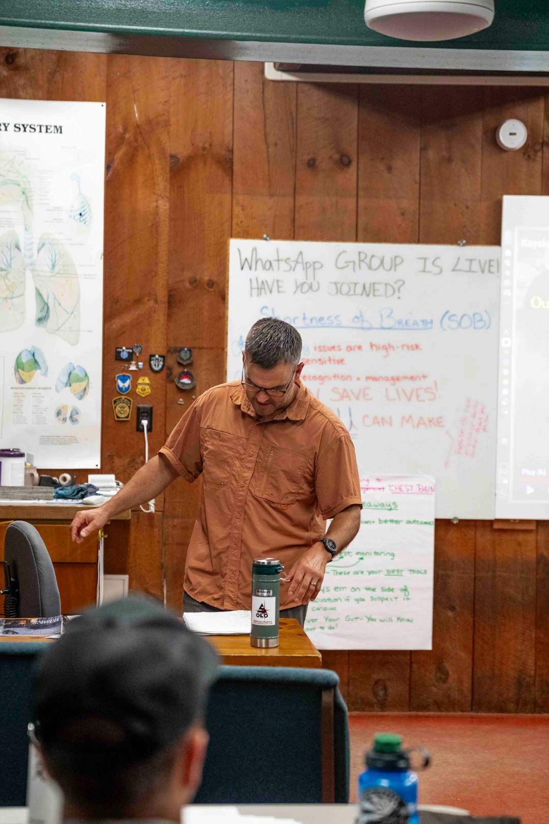 man-in-orange-shirt-presenting-in-front-of-whiteboard-uwdds-mipha