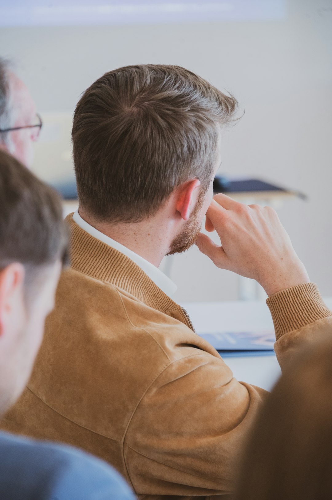 man-in-a-brown-jacket-at-a-meeting-srgpe0eucxq